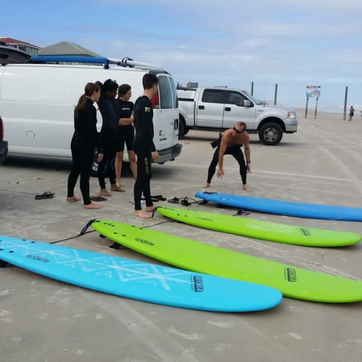 Surf lesson group with boards on the beach